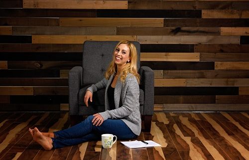 Allison health coach smiling sitting on couch