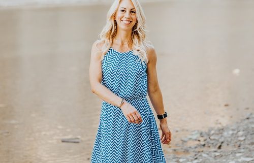 Allison health coach walking along a beach smiling