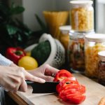 faceless woman chopping bell pepper during lunch preparation in kitchen