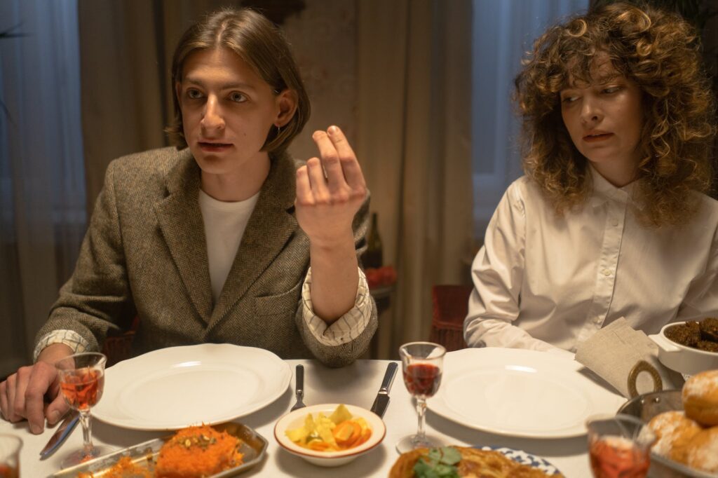 man in gray blazer sitting beside woman in white shirt