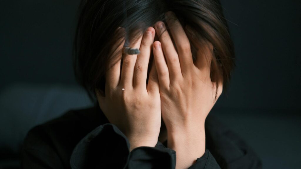 woman covering face in emotional distress