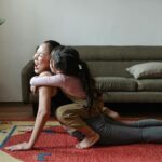 photo of girl hugging a woman while doing yoga pose
